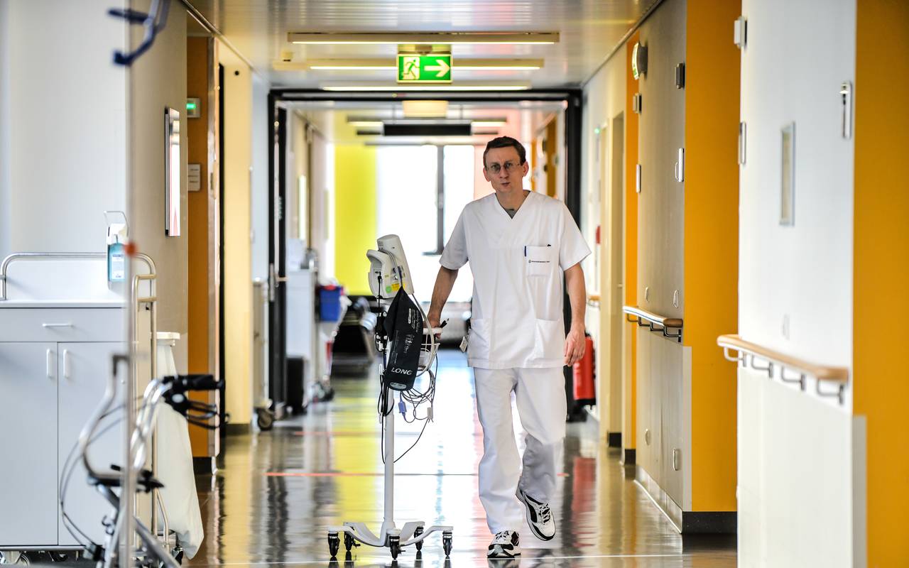 Ein Krankenpfleger geht über den Gang in einer Station des Universitätsklinikums Essen.
