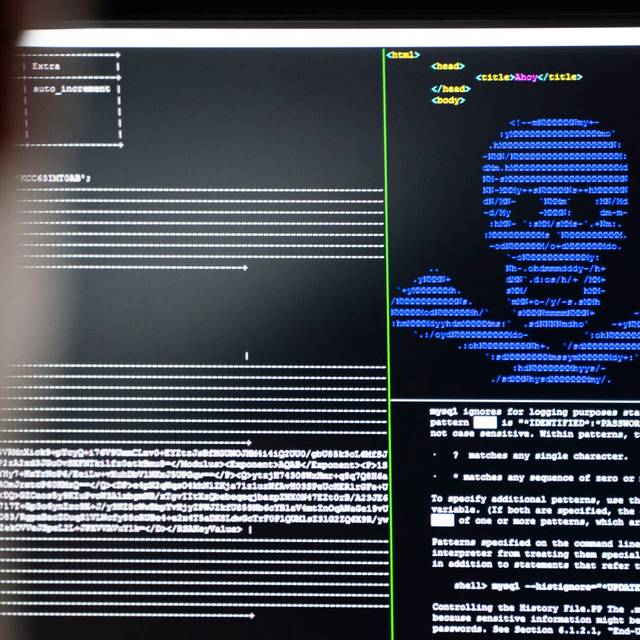 Die Cyberkriminalität erklärt am Symbolbild mit einem Computer, auf dem ein Totenkopf erscheint