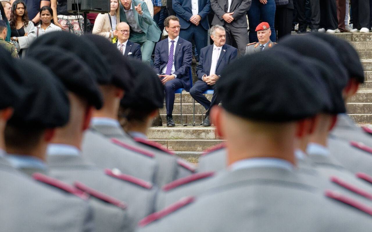 André Kuper (CDU, hinten, l-r), Präsident des Landtags von Nordrhein-Westfalen, Hendrik Wüst (CDU), Ministerpräsident von Nordrhein-Westfalen, Herbert Reul (CDU), Innenmister von Nordrhein-Westfalen, und Brigadegeneral Hans-Dieter Müller verfolgen das Gelöbnis. Rund 420 Rekruten der Bundeswehr geloben vor dem Landtag in der nordrhein-westfälischen Landeshauptstadt ihren Fahneneid.