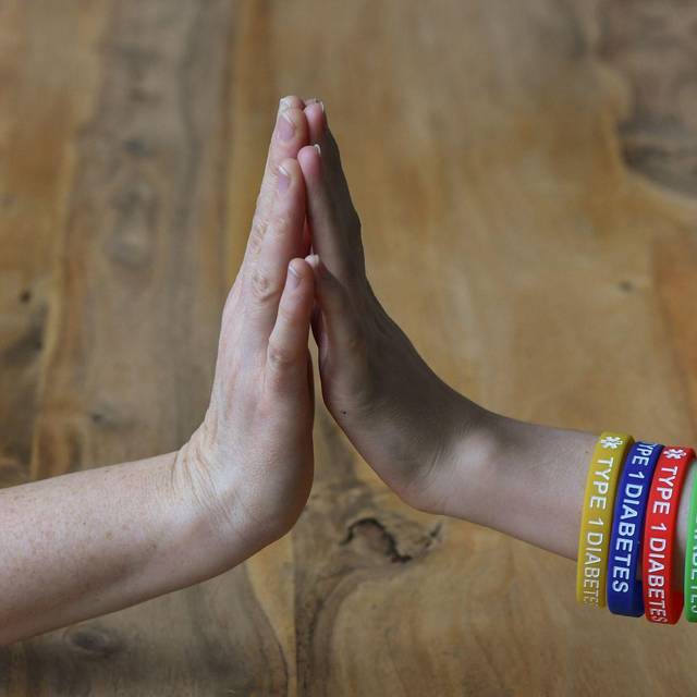 Eine Person trägt Armreifen mit der Aufschrift "Diabetes Type 1"