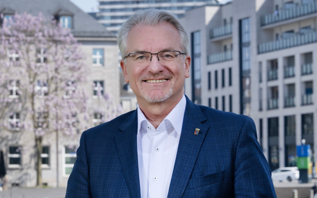 Oberbürgermeisterkandidat Marc Buchholz vor einem städtischen Hintergrund