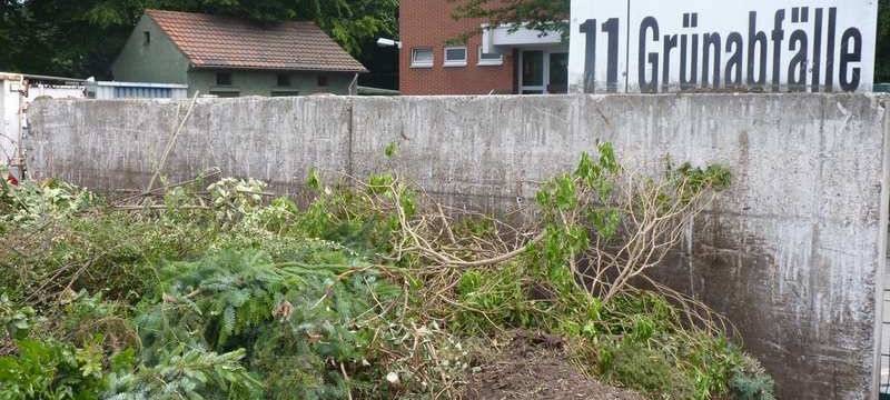 Grünabfälle auf Betreibshof mit dazugehörigem Schild.