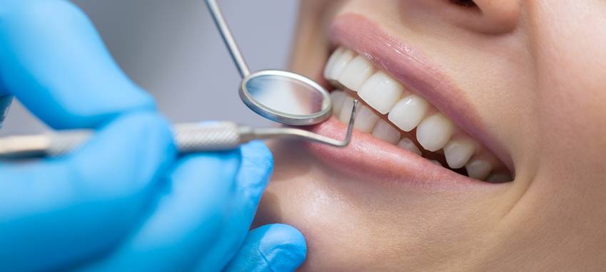 Ein Zahnarzt untersucht eine Patientin im Behandlungszimmer.