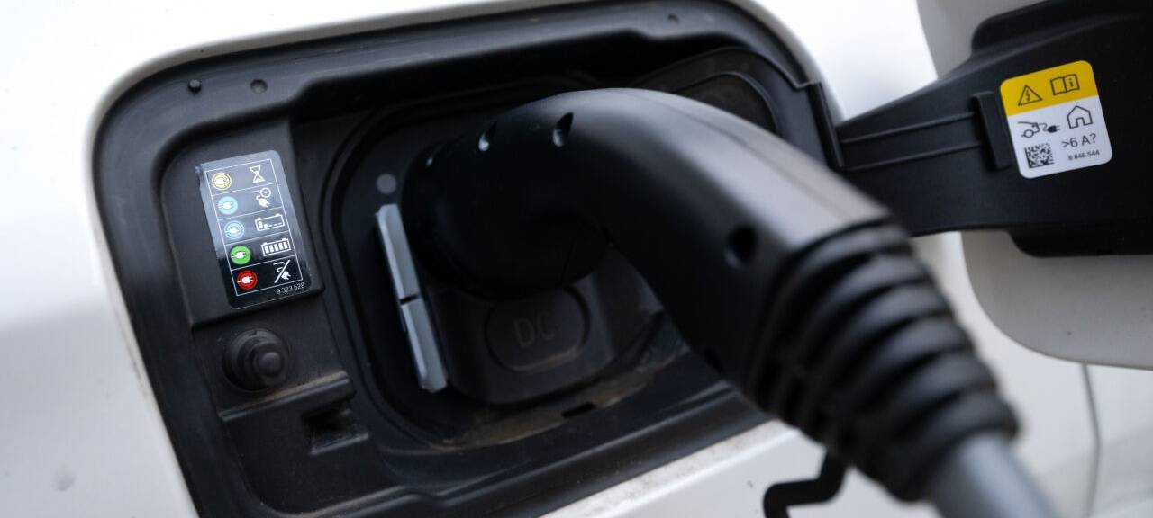 Der Stecker einer Ladesäule ist beim Ladevorgang an einem Auto zu sehen.