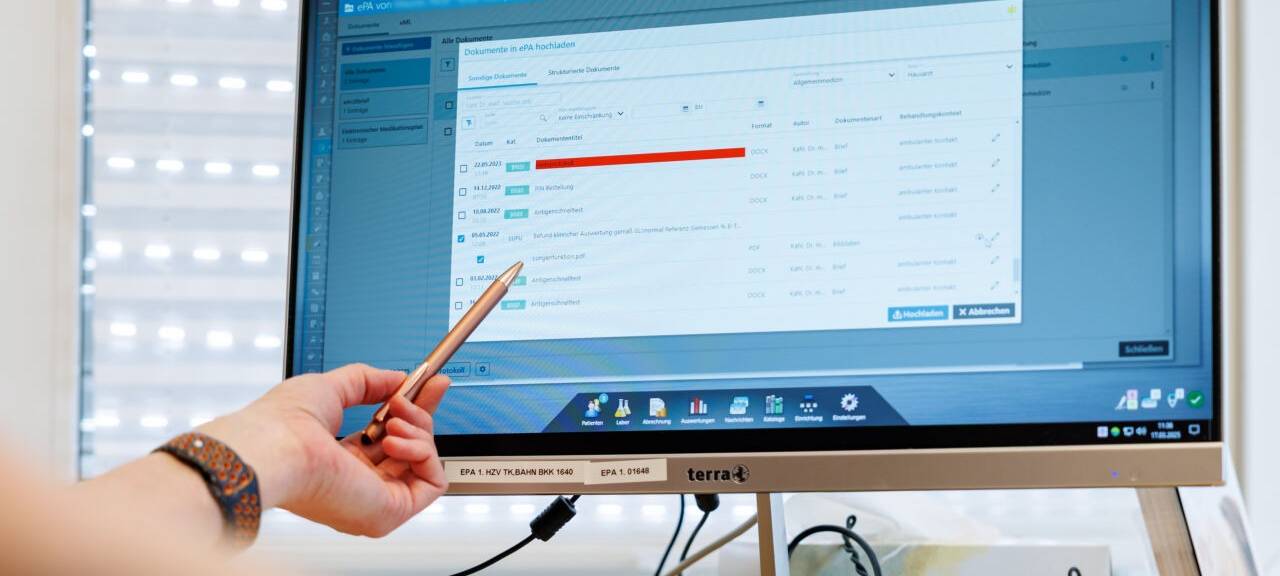 Ein Hausarzt lädt in seiner Praxis Dokumente in eine elektronische Patientenakte "ePA".