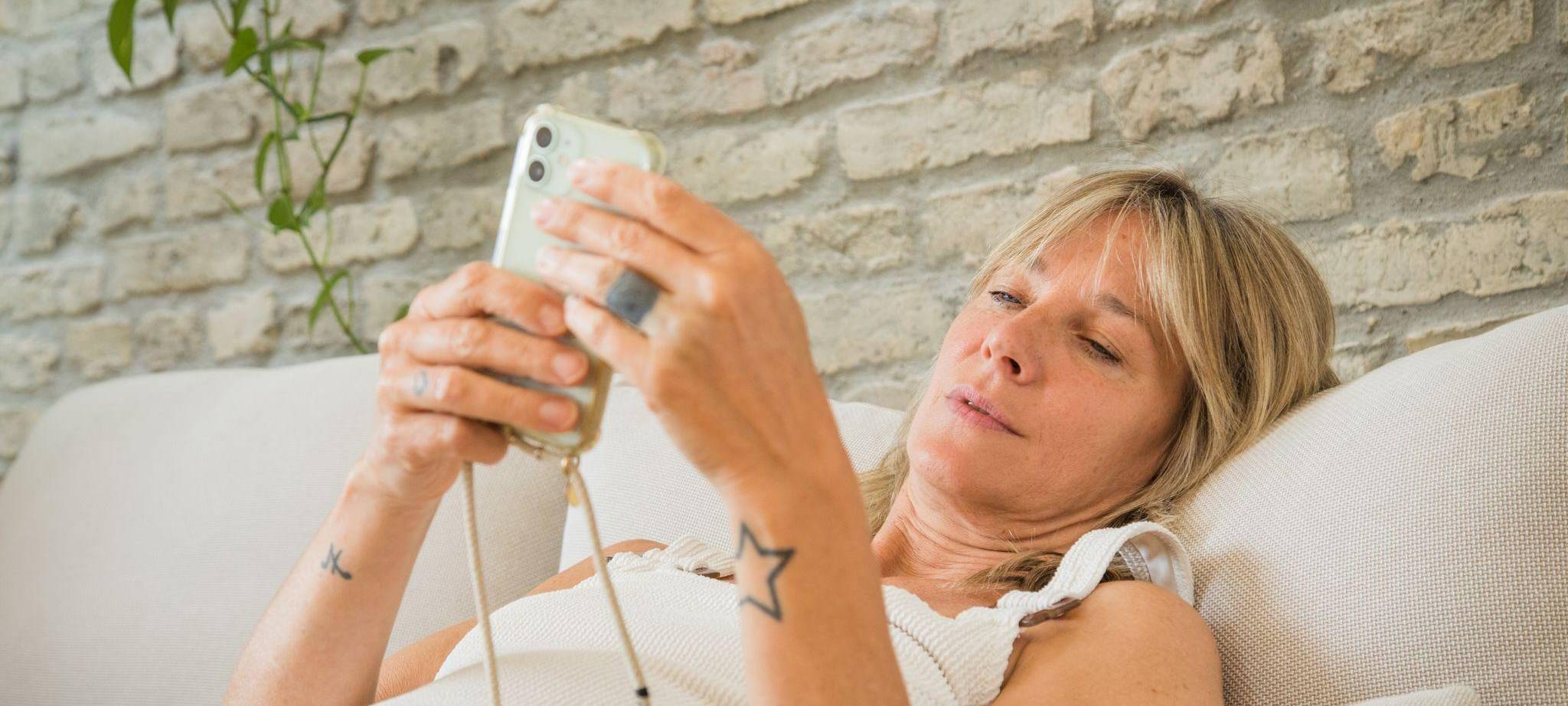 Frau mit Smartphone im Wohnzimmer
