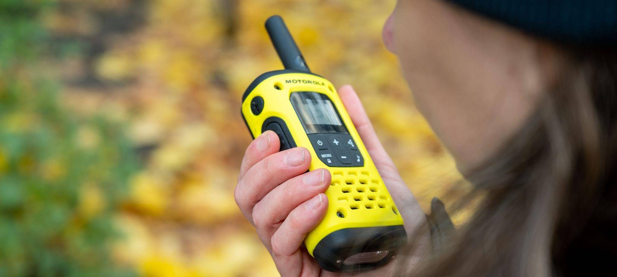 Eine Frau spricht in ein Walkie-Talkie in ihrer Hand