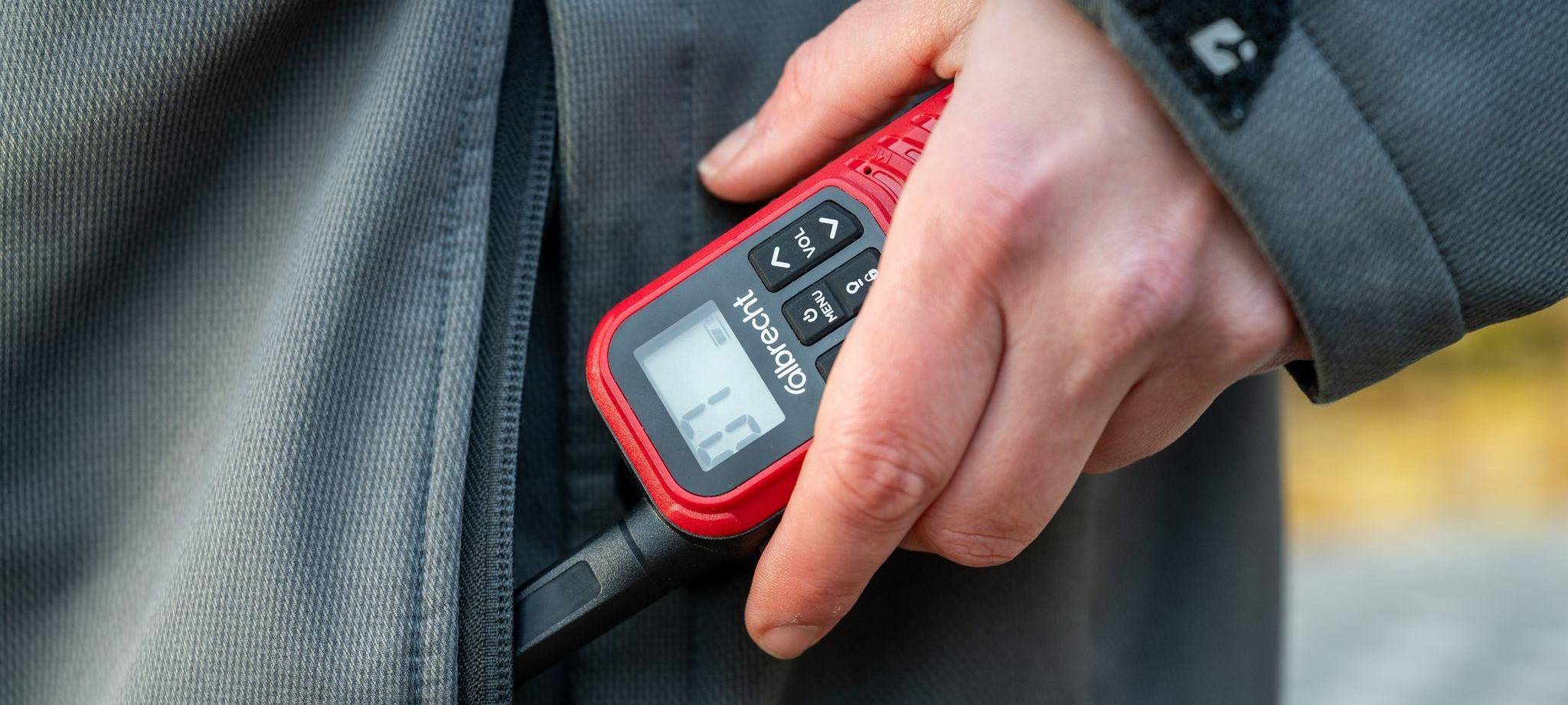 Eine Frau holt ein Walkie-Talkie aus ihrer Jackentasche