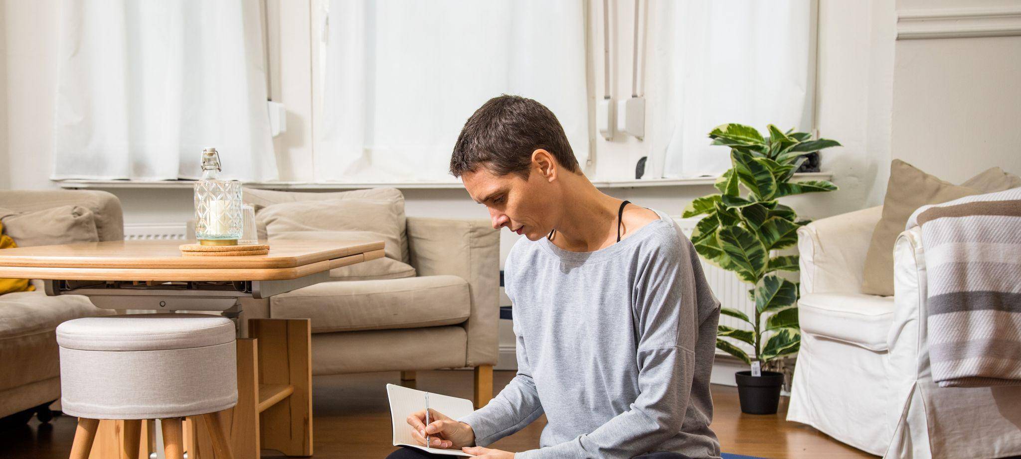 Frau schreibt ihre Gedanken in ein Notizbuch